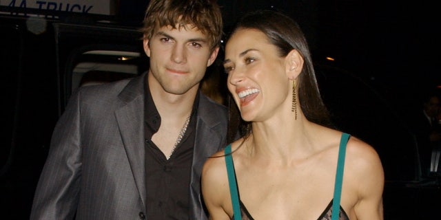 Demi Moore shows some skin wearing a sheer green dress with black lace bra for date with Ashton Kutcher