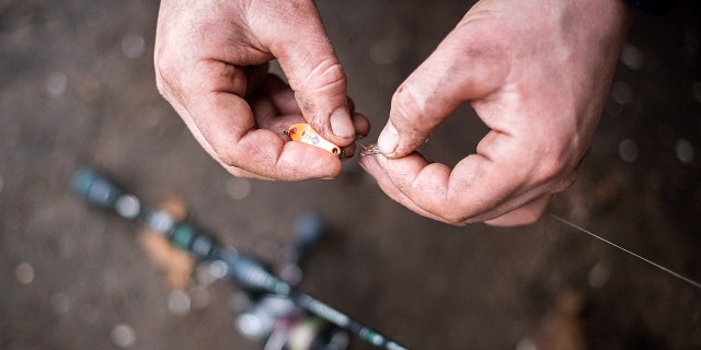 Man attaching bait to a fishing pole