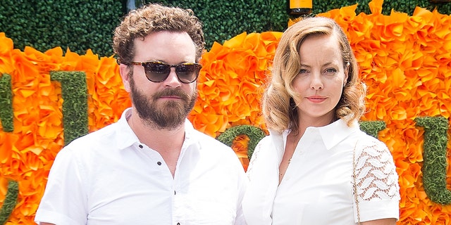 Danny Masterson and Bijou Phillips in front of flowers