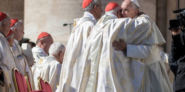 Pope Francis embraces cardinals