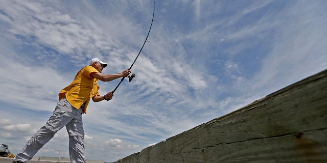 A man casting a fishing pole
