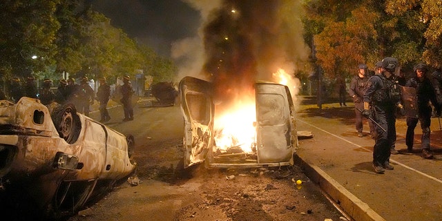 A vehicle is consumed by flame during riots in Nanterre, outside of Paris