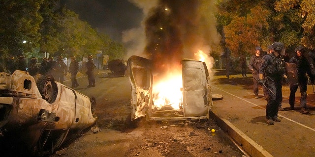 A vehicle is consumed by flame during riots in Nanterre, outside of Paris