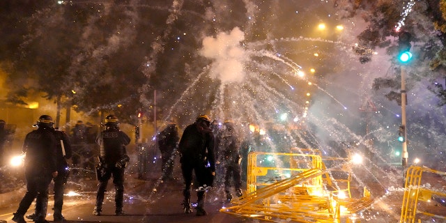 French police fire tear gas back at protesters who are launching fireworks at them in Nanterre, outside of Paris