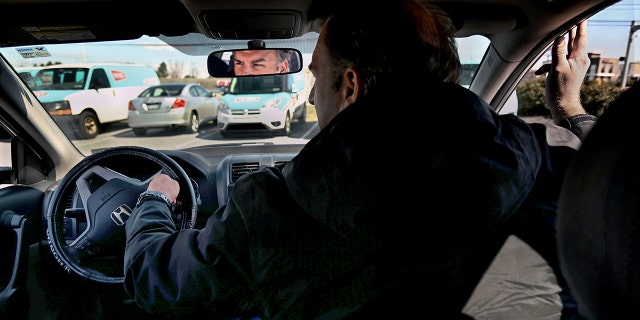 Former postal worker Gerald Groff demonstrates how postal service workers drive their trucks