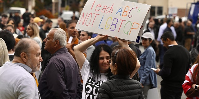 A protester holds a sign that reads, "teach ABC's not LGBTQP"