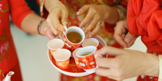 A newlywed serves tea during a traditional Chinese tea ceremony.