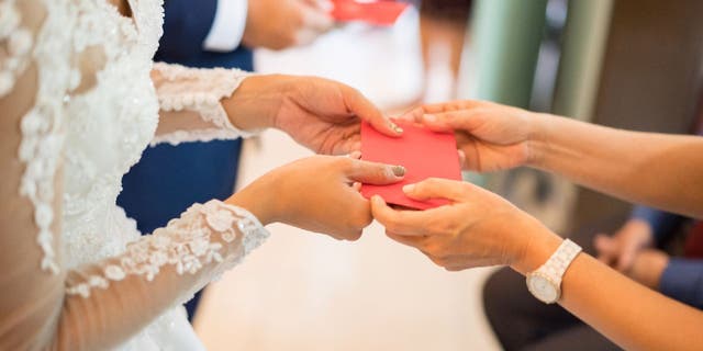 Newlyweds receives money in red envelopes.