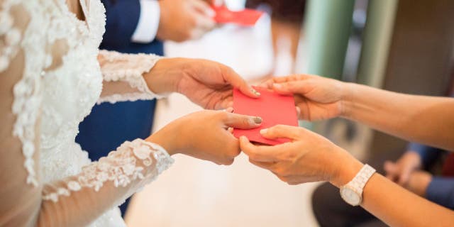 Newlyweds receives money in red envelopes.