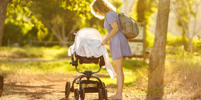 draped stroller with mom attending baby