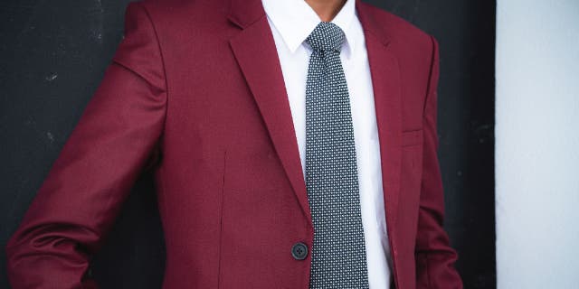 Man wearing a dark red suit.