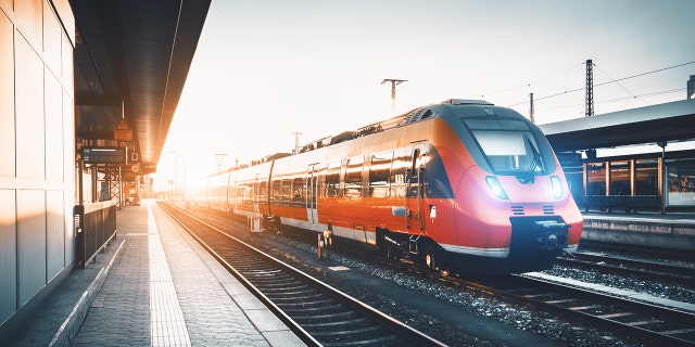 red commuter train on tracks