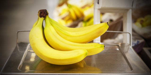 A bunch of bananas sitting on a cashier checkout scale.