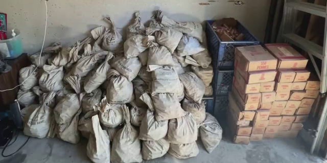 Dozens of bank bags sit next to crates of penies