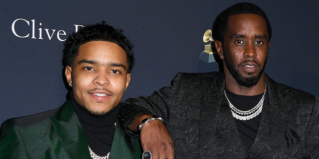 Sean Combs wears black paisley print suit with son Justin Combs in green blazer at event