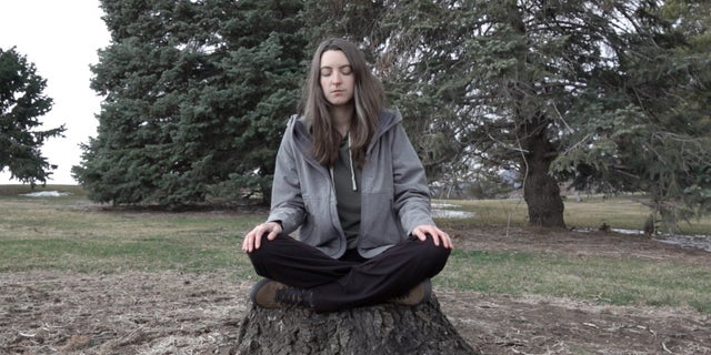 Psychedelic Club president meditates on a stump