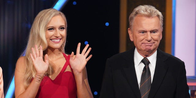 Maggie Sajak stands next to father Pat Sajak on the "Wheel of Fortune" set.
