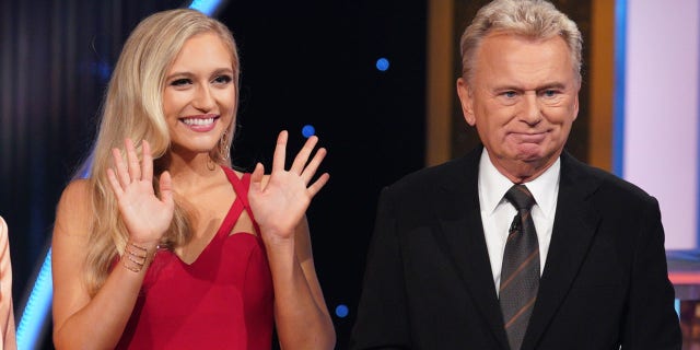 Maggie Sajak stands next to father Pat Sajak on the "Wheel of Fortune" set.