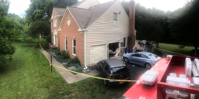 fire truck and officials at scene of damaged home