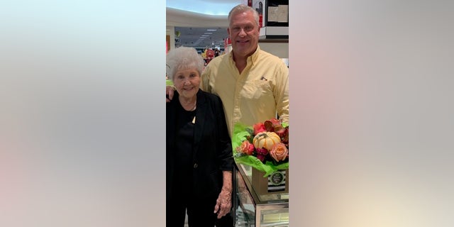 Woman standing next to taller man bouquet of flowers on the right