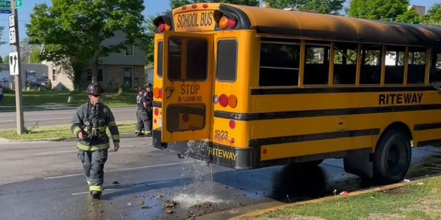 Firefighters dousing bus that was on fire