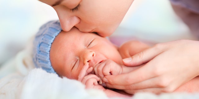 Mom kissing preemie baby