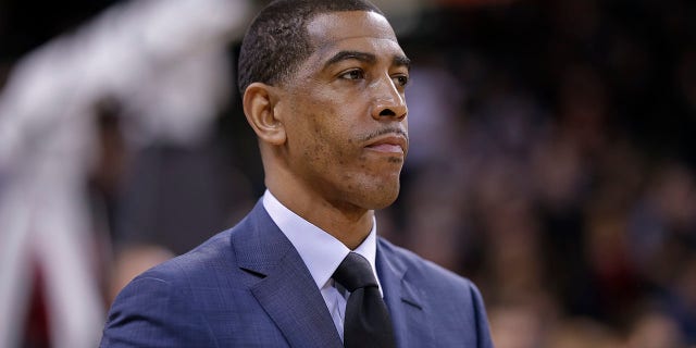     Kevin Ollie looks at the court