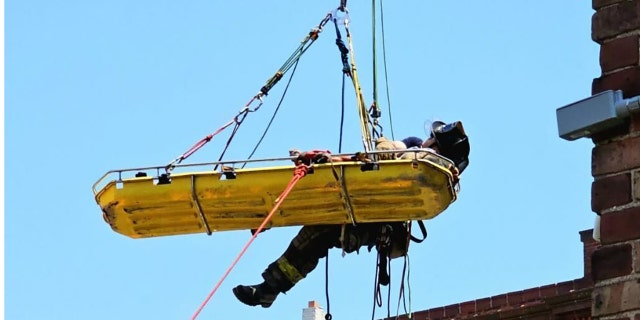Person being airlifted from building on stretcher