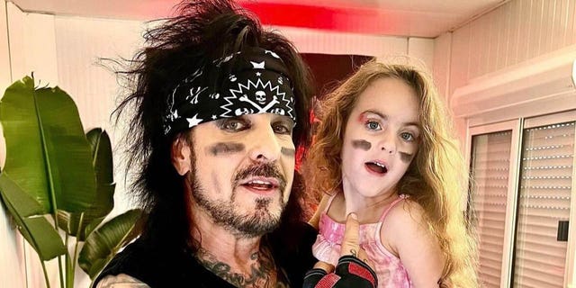 nikki sixx holding daughter ruby with both wearing face makeup