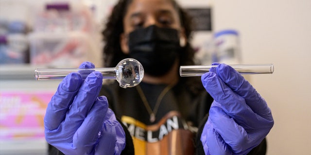 Harm reduction staff member holds a glass pipe
