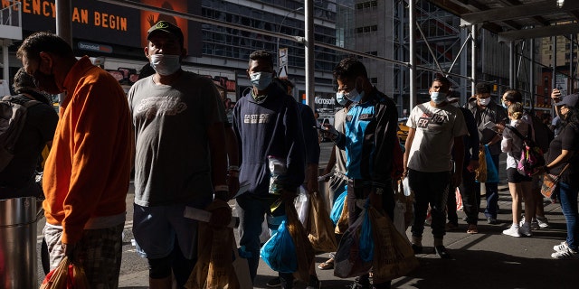 migrants wait in line