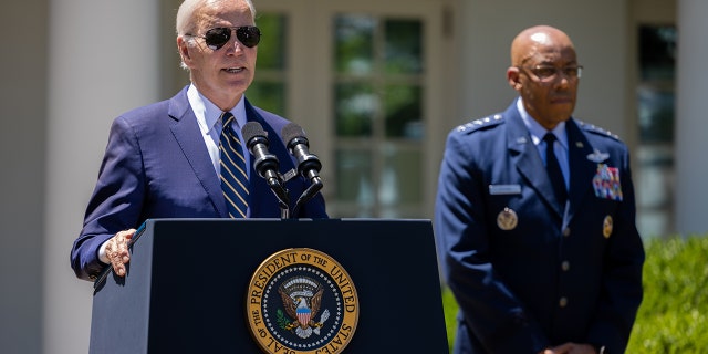 President Biden speaks from a podium at the White House as Air Force Gen. Charles Q. Brown Jr. stands beside him