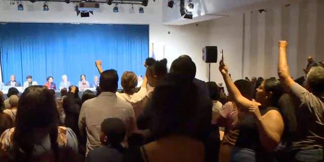 Crowd stands and chants for reparations