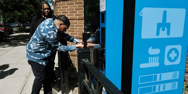 A Services for the Underserved worker opens a new public health vending machine