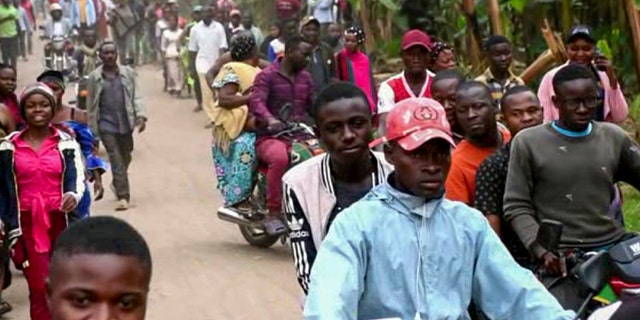 La gente se dirige a la escuela secundaria de Luberiha después de un ataque a la escuela cerca de la frontera con el Congo.