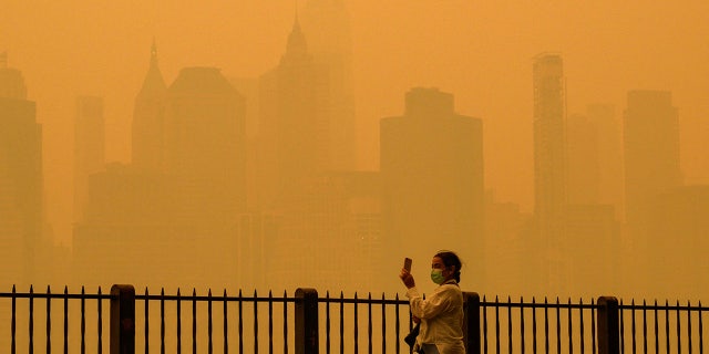 woman taking picture of New York sky