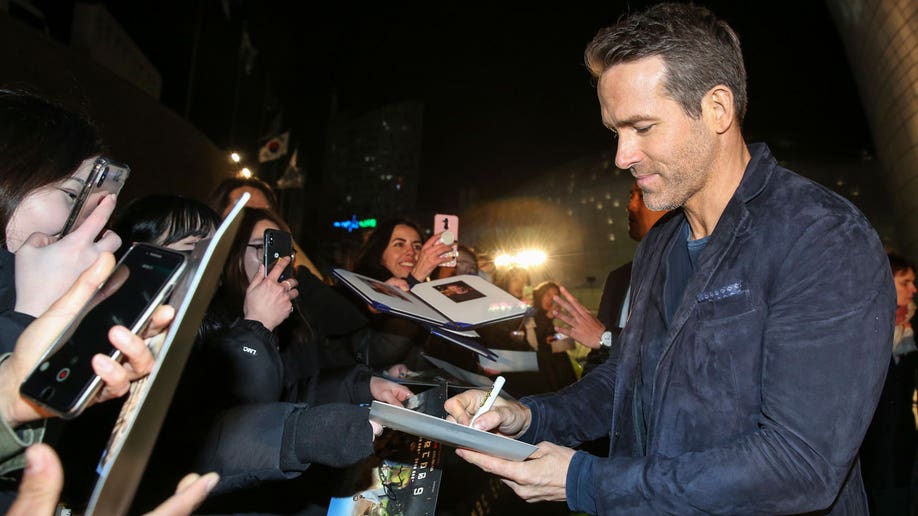 Ryan Reynolds signing autographs