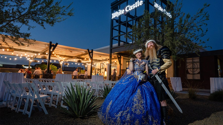 Jamie West and Drew Schmitt pose for a portrait on their wedding night.