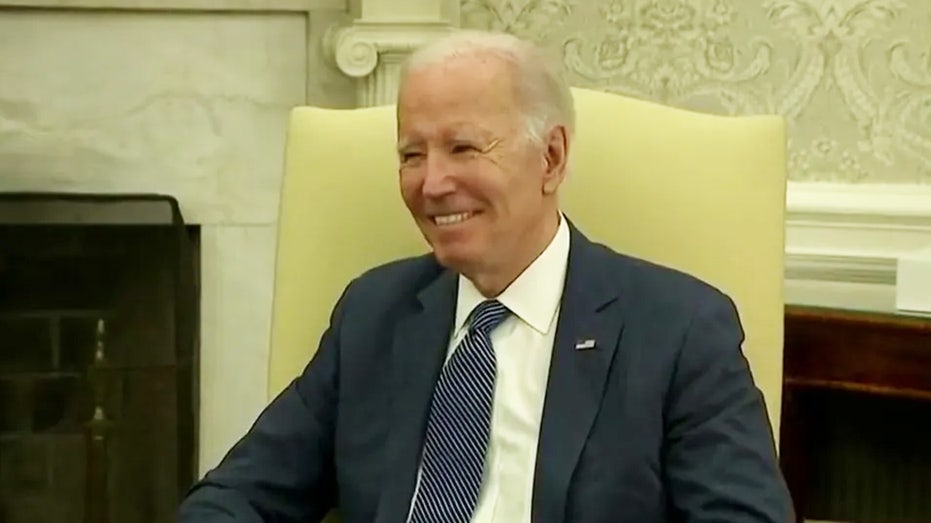 Biden laughs and smirks as the press is ushered out of the Oval Office without questions