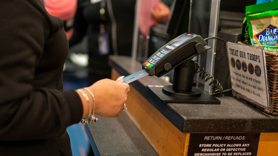n air traveler uses a credit card to pay for items on January 28, 2022 at a retail shop in John F. Kennedy International Airport in New York City. 