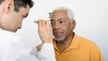 Mature male doctor testing an African American patient's eye in clinic