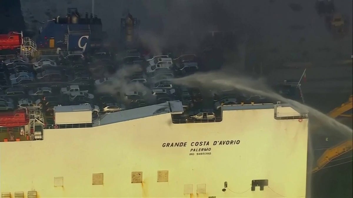 cars on deck of cargo ship with smoke