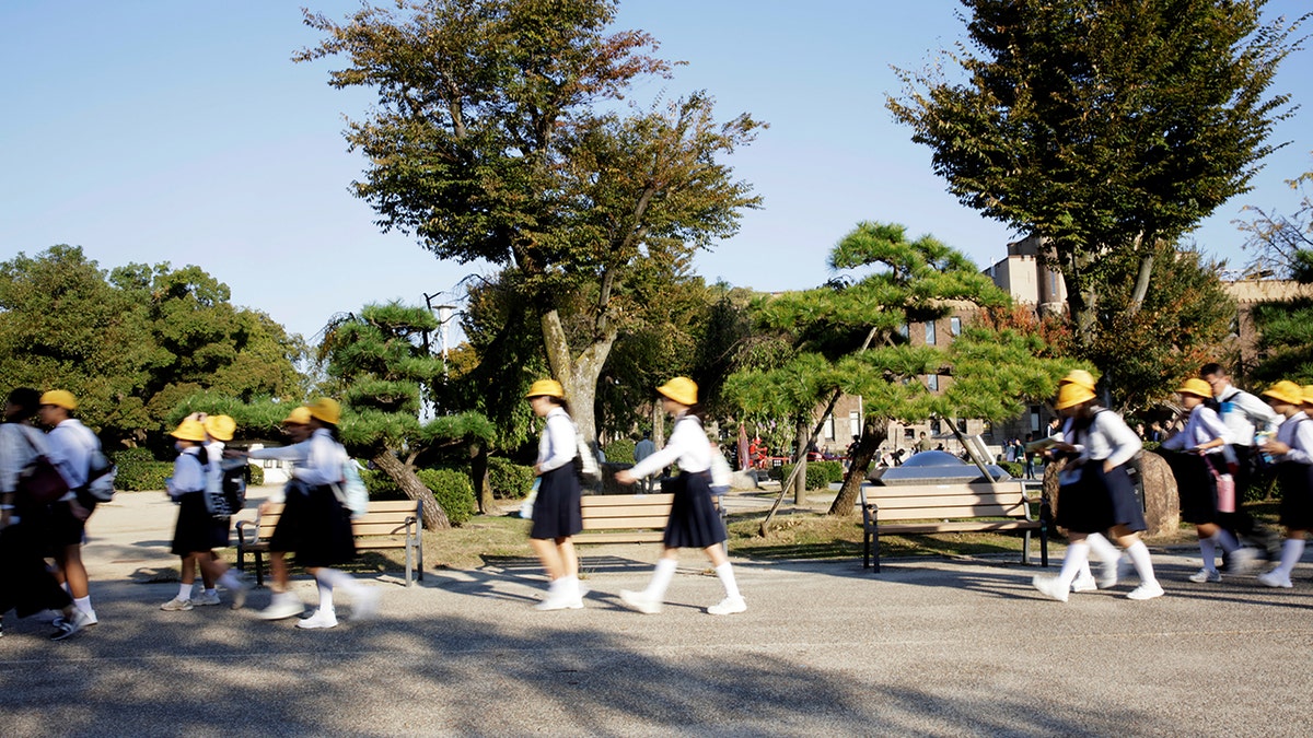 School children walk on a day tour of the Osaka Castle October 26, 2017.