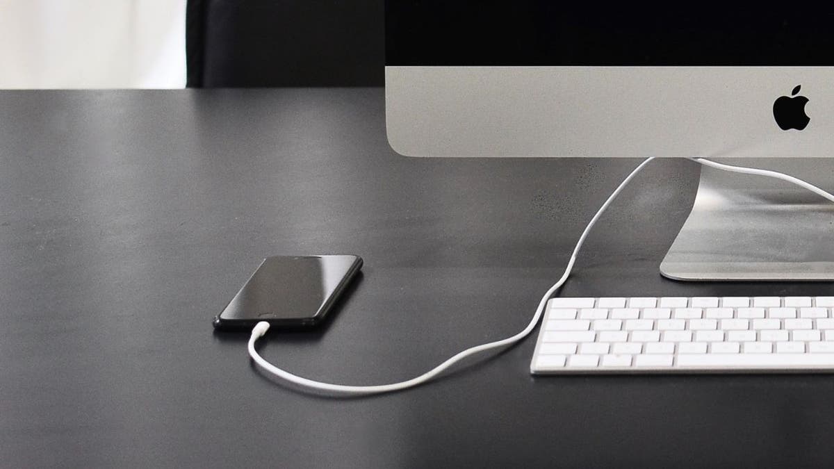 iPhone plugged into Mac desktop