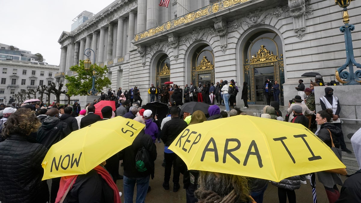 A crowd listens to speakers at a reparations rally outside of City Hall in San Francisco, on March 14, 2023.