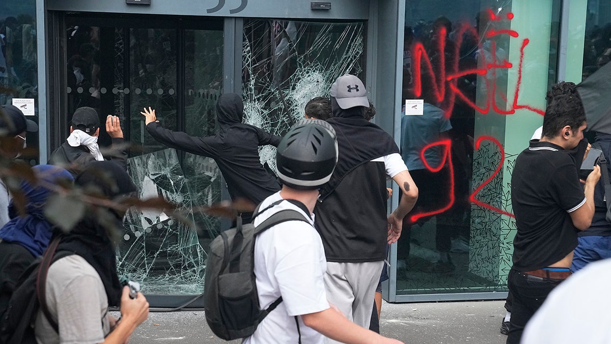 Young people vandalize window during French riots