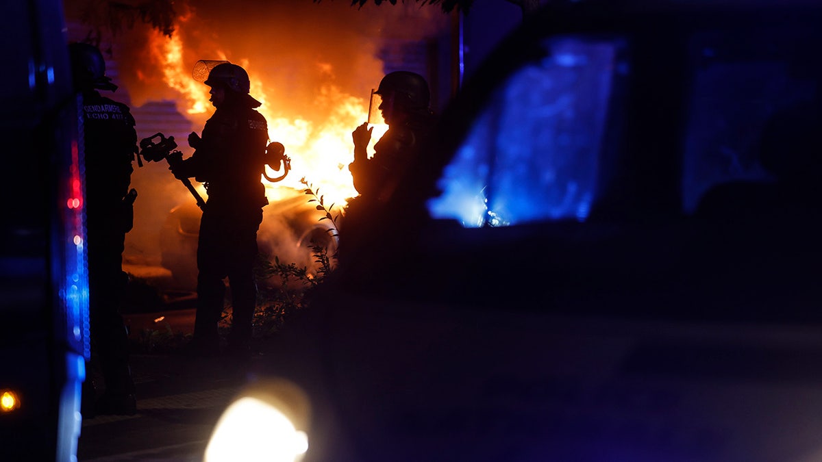 Car burning in the street as French police respond to riots