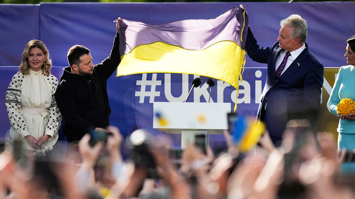 Zelenskyy holding a Ukraine flag