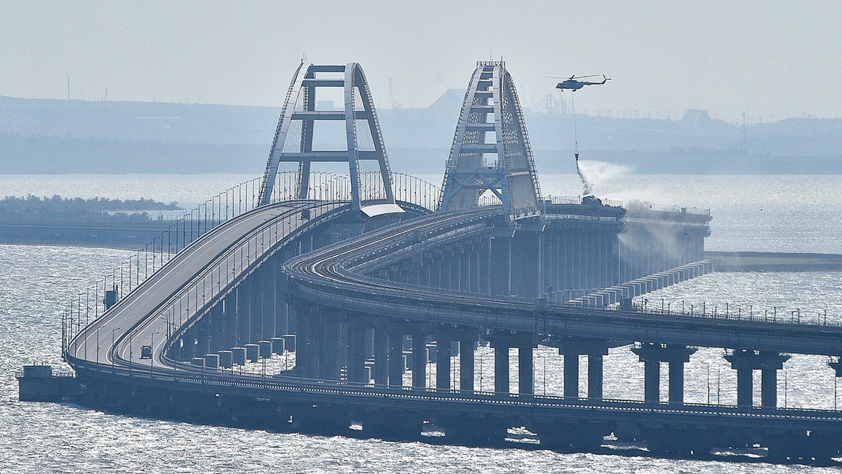 Helicopter drops water on bridge connecting Crimea and Russia