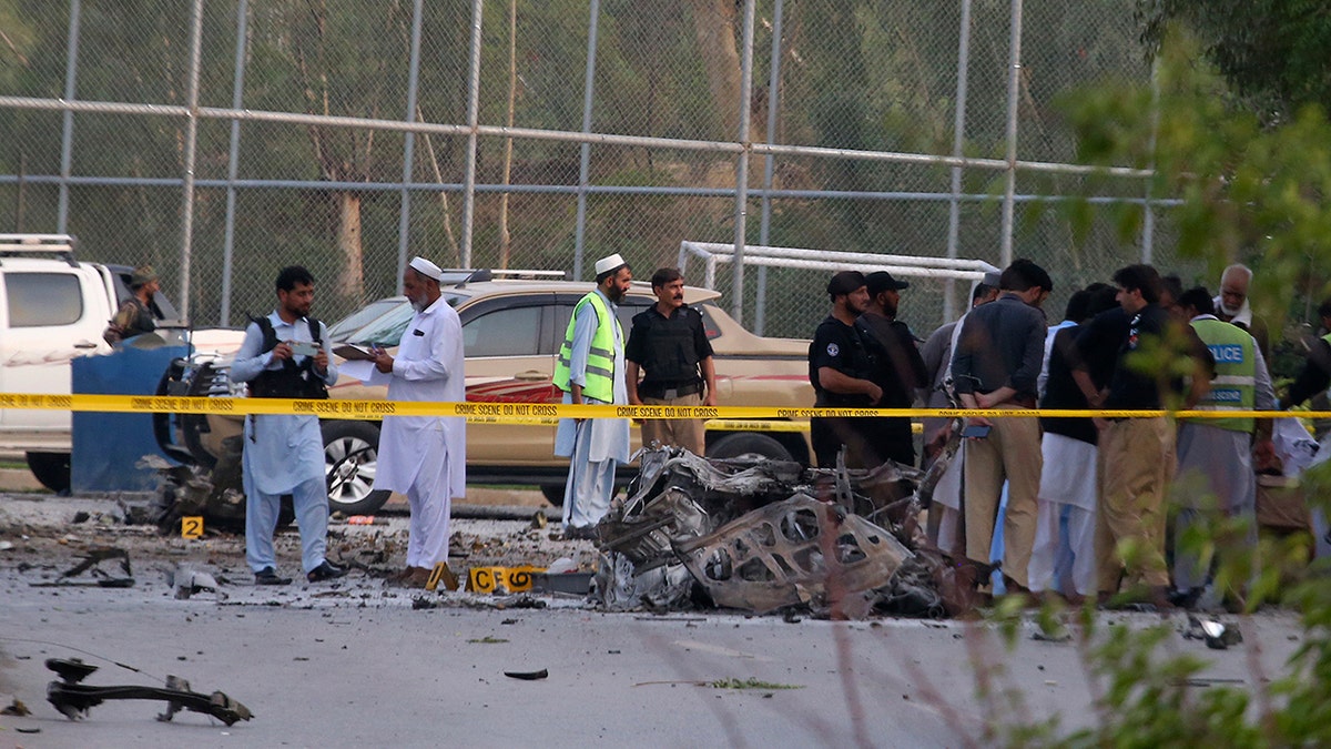 Security personnel inspect the site of a suicide bomber attack